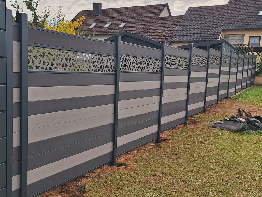 Zweifarbiger WPC-Sichtschutzzaun mit Ornament-Blende als oberem Abschluss