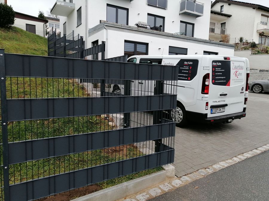 Doppelstabmattenzaun in Anthrazit mit eingezogenen Sichtschutzstreifen an einer Straße