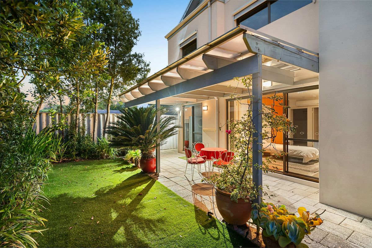 Terrassenüberdachung aus Aluminium mit Glasdach an einem Wohnhaus im Garten