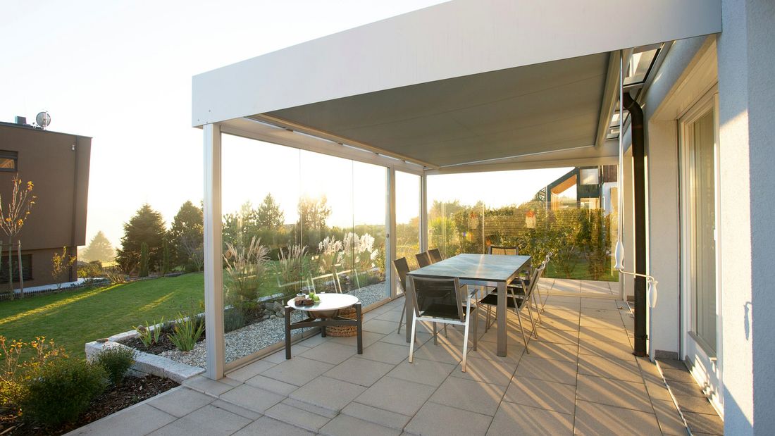 Terrassenüberdachung aus Aluminium mit Glasdach an einem Wohnhaus